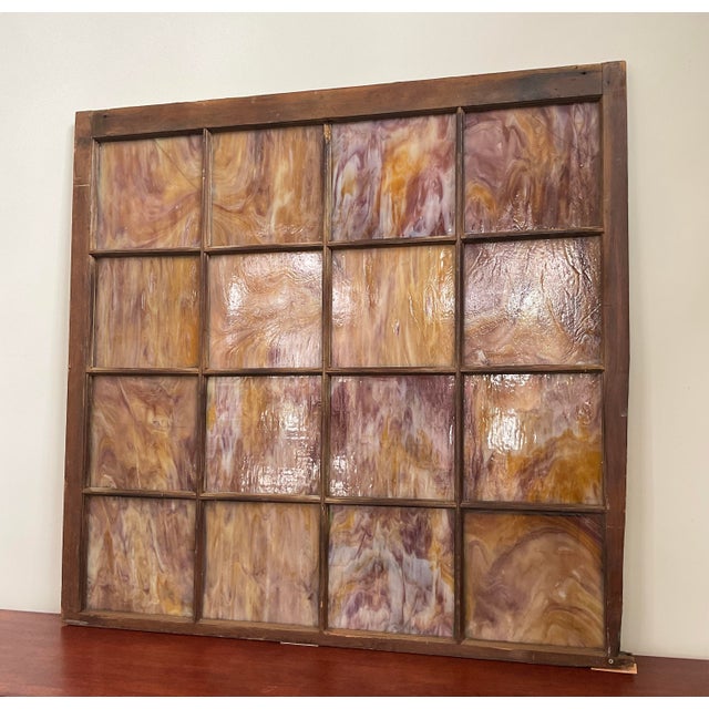 Bring a piece of striking architectural history into your space with this stunning antique multi-pane slag glass window...
