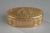 Three-tones gold oval snuff box. The hinged lid is decorated with a country trophy medallion. The medallion is framed by a...