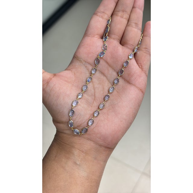 This station tennis necklace features 29.28 carats of natural blue sapphires, set in 14k yellow gold. Each sapphhire...