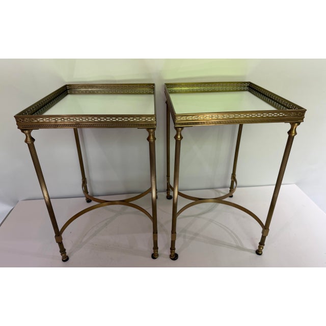 Elegant pair of Global Views accent or side tables featuring an antique brass finish with inset glass tops. Each table is...