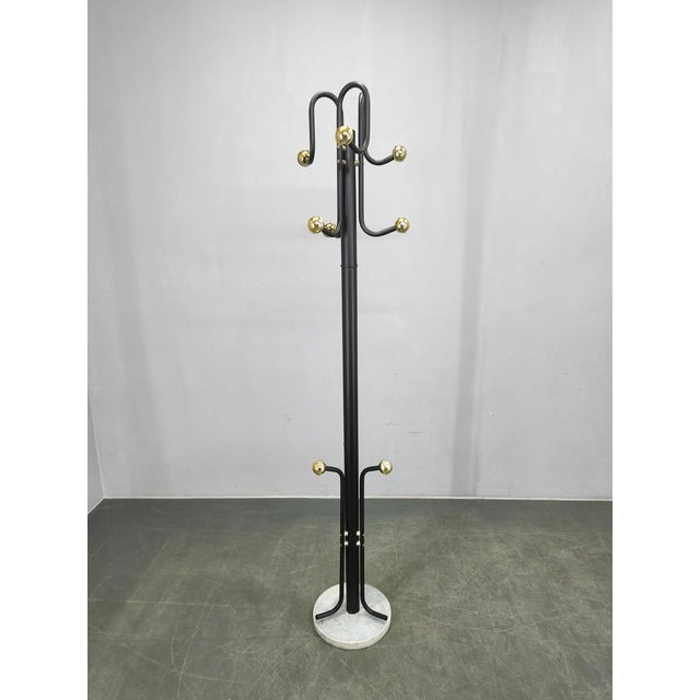 Italian mid-century coat rack from the 1970s with a clean architectural silhouette. The piece features a black lacquered...