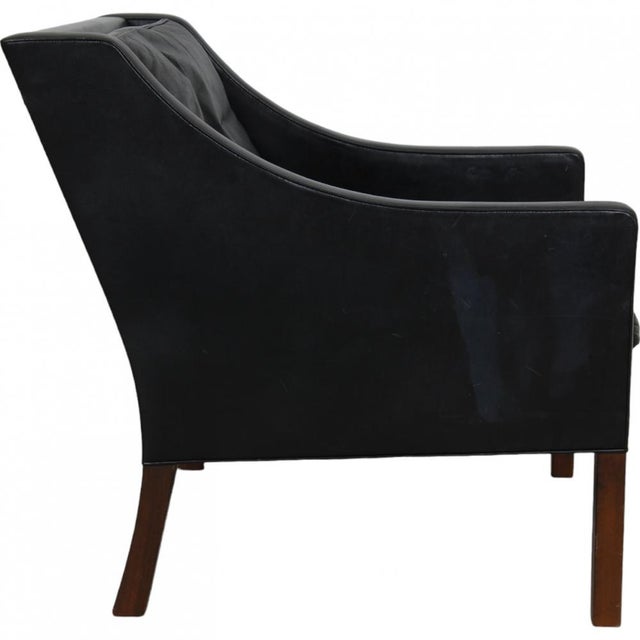 Børge Mogensen 2207 lounge chair upholstered in black leather, and with legs of teak. The chair is from the 1980s and...