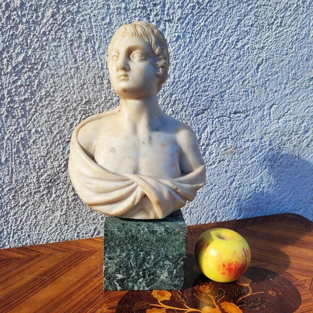 Marble bust depicting a young man wearing a toga or draped garment. 17th-century marble, with a later green marble base....