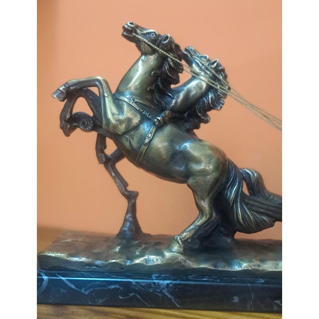 Antique bronze figure depicting a Roman quadriga, showing a charioteer or gladiator driving a two-horse chariot at full...