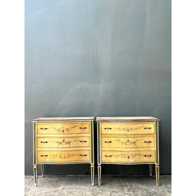 A pair of vintage hand-painted wood chests, likely dating from the mid-20th century, showcase a charming patina that...
