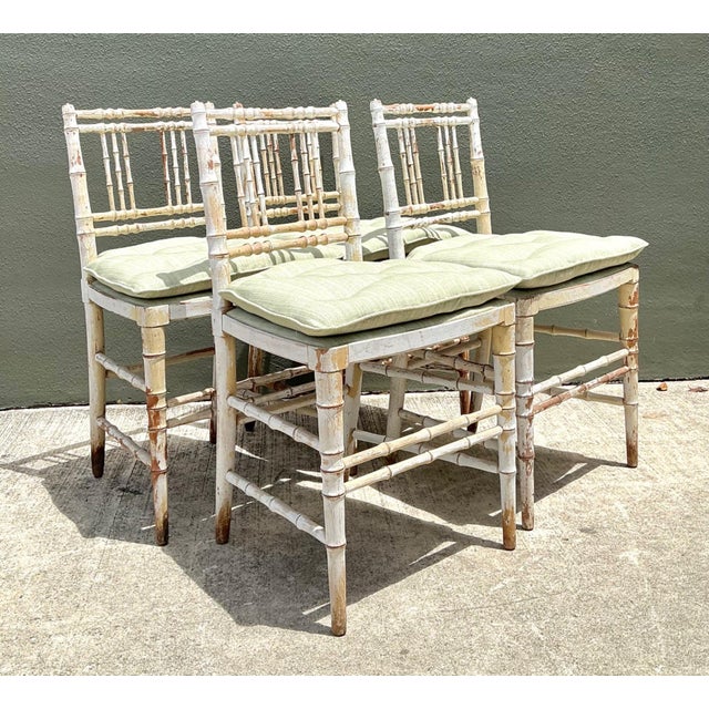 This set of four vintage faux bamboo spindle back chairs beautifully captures the enduring appeal of late 19th-century...