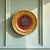 A charming Italian neoclassical wall plaque featuring a cast bronze classical medallion mounted against rich red velvet...