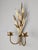 A vintage Hollywood Regency style brass candle sconce with wheat motif and two candle holders.