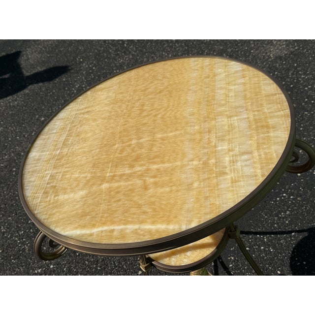 A beautifully crafted marble and iron side table featuring an ornate scrollwork base and a sculptural silhouette. The...