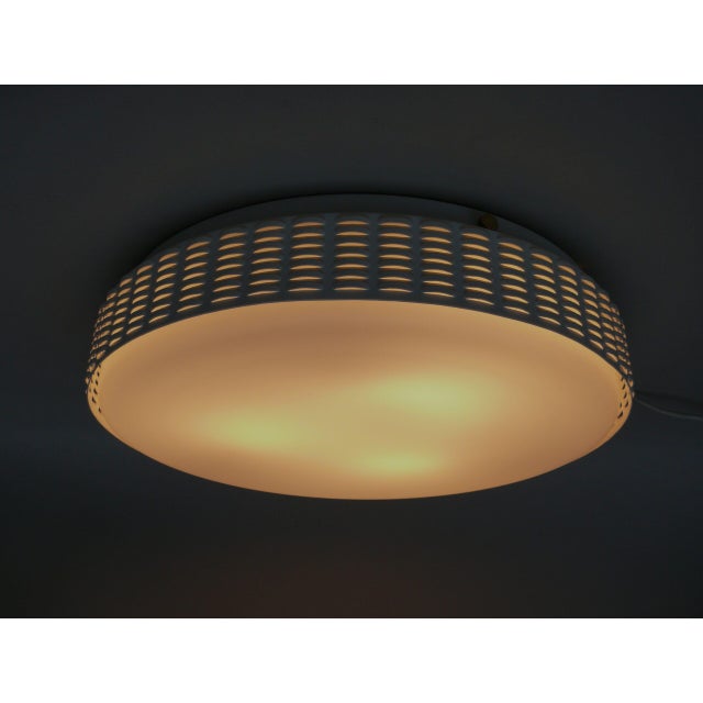 A minimalist, timelessly elegant ceiling light from the 1960s, made in Germany. The combination of the glossy white...