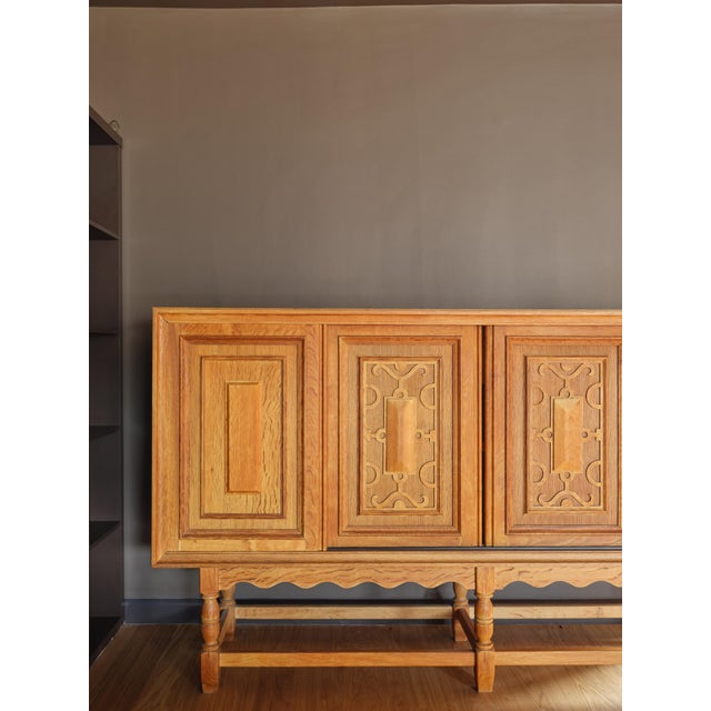 An exquisite tall sideboard cabinet attributed to Henning (Henry) Kjaernulf; featuring a scalloped apron and raised panel...