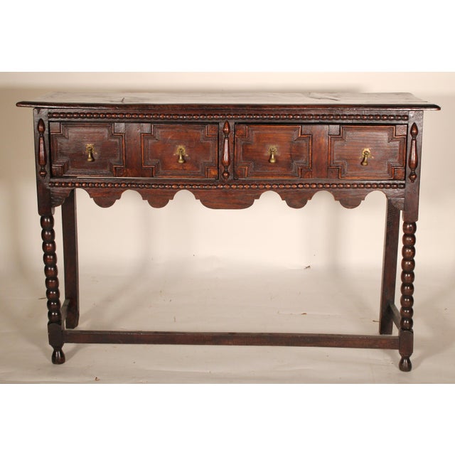 Antique Jacobean style oak sideboard, 19th century. With a rectangular single board top with molded front and side edges,...