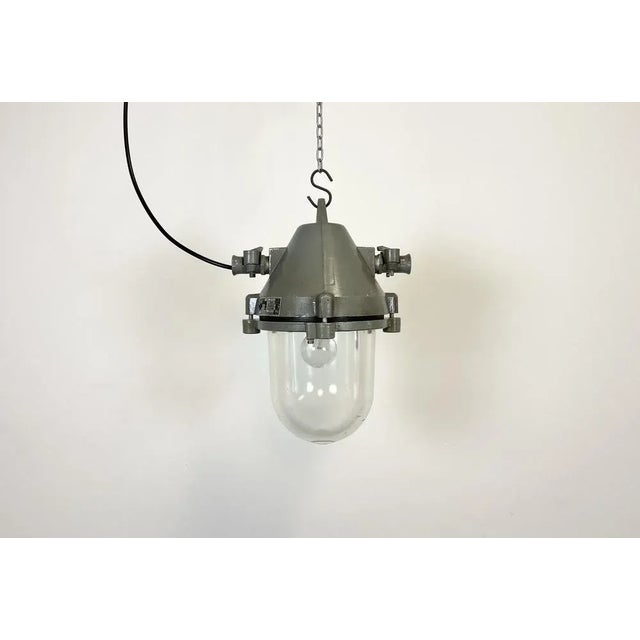 Dark grey industrial light with massive protective glass bulb. Made in former Czechoslovakia by Elektrosvit during the...