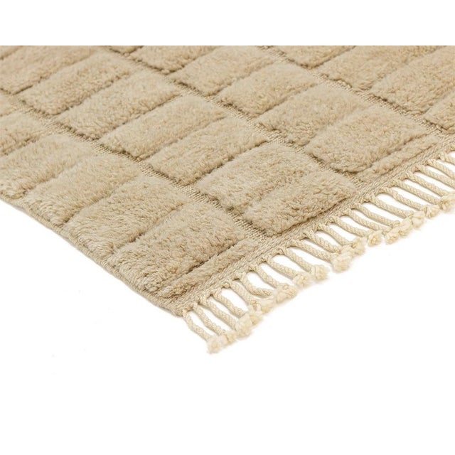 A checkerboard felt more than seen: soft squares carved in warm, velvety fawn. A tone-on-tone checkerboard covers the rug,...
