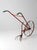 Antique single-wheel garden cultivator with a large spoked iron wheel, curved cultivating tines, and long metal handles....