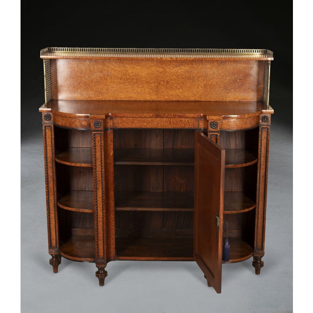 A smart regency amboyna side cabinet well figured top with raised structure supported by brass columns and grills topped...