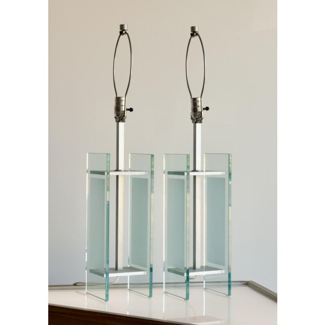 This is a pair of postmodern table lamps constructed from panels of clear and frosted glass set into a brushed aluminum...