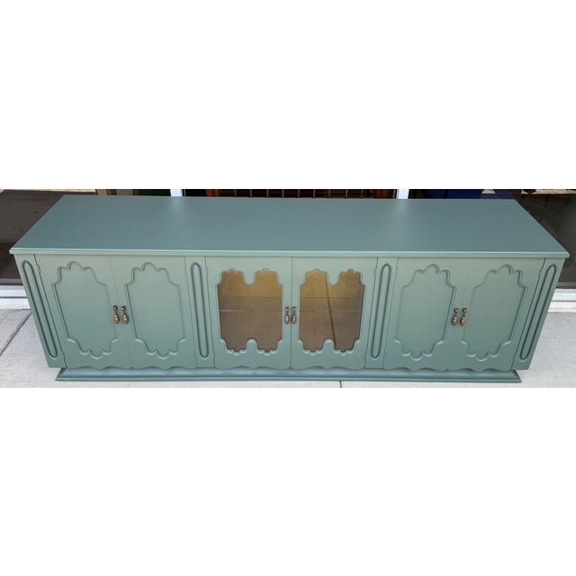 Extra-long, custom-painted vintage credenza finished in a striking sage or forest green tone. The piece blends...