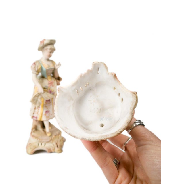 A pair of 19th-century Meissen porcelain figurines in Rococo Revival style, depicting a romantic couple in floral...