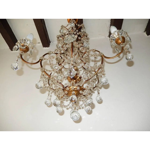 Housing four lights total. Three encircling sitting in crystal bobeches on gold gilt posts, the other light is on top...