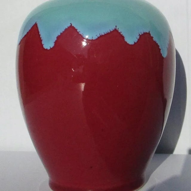 Classic urn shape with sky blue pouring over the shoulders meeting a lower body of red. Glazed to the inside in blue and...