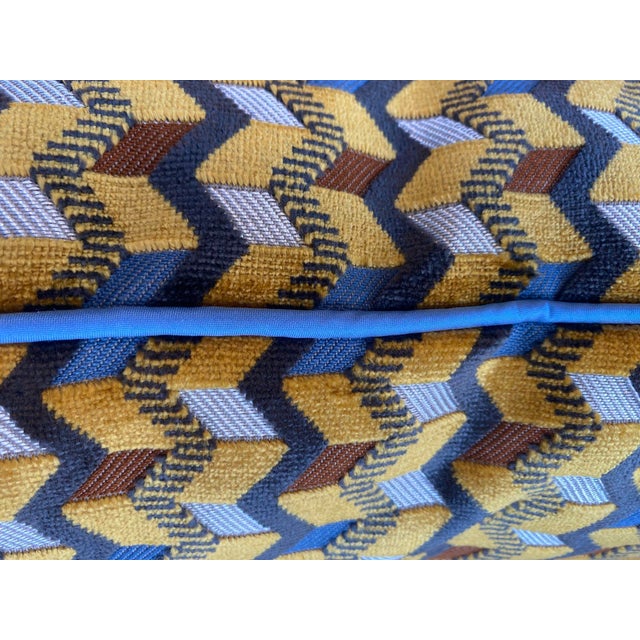 This custom pillow features a striking geometric design with a textured chevron pattern in shades of mustard yellow, blue,...