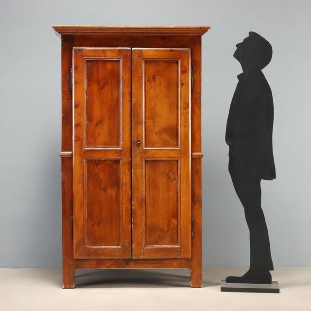 Two-part larch wardrobe dating back to the mid-19th century, crafted in Italy. The structure features a pair of bipartite...