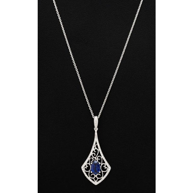 14K White Gold Sapphire Diamond Necklace, featuring one centered prong set oval brilliant cut blue sapphire weighing...