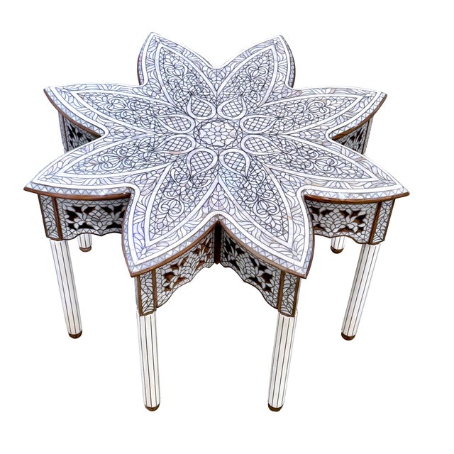 A striking handcrafted coffee table featuring an elegant flower-inspired silhouette and an intricate all-white mother-of-...