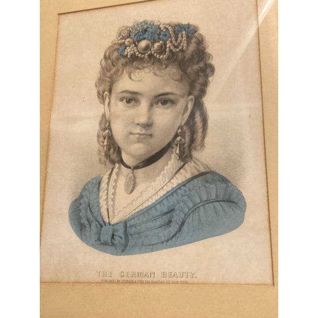 A real The German Beauty famous 19th-century Currier & Ives hand-colored lithograph titled "The German Beauty". It is a...