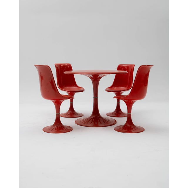 The Tulip dining set, featuring a central table and four matching chairs, boasts organic lines and a space-age spirit....