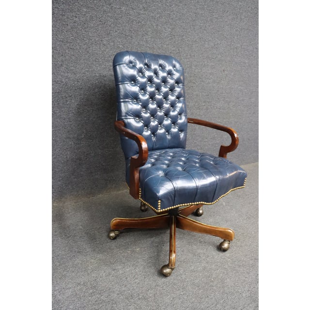 Leathercraft swivel office chair upholstered in deep blue tufted leather with button detailing on the back and seat....