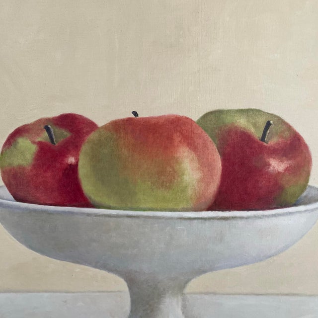 A still life painting by Elise Manville. The hyper realistic painting depicts a bowl of apples. The painting was made in...