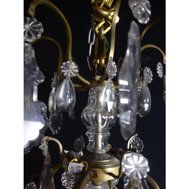 Large, elegant eight-light bronze and crystal chandelier. Dimensions: 1.20 m high and 0.65 m diameter for the widest part....