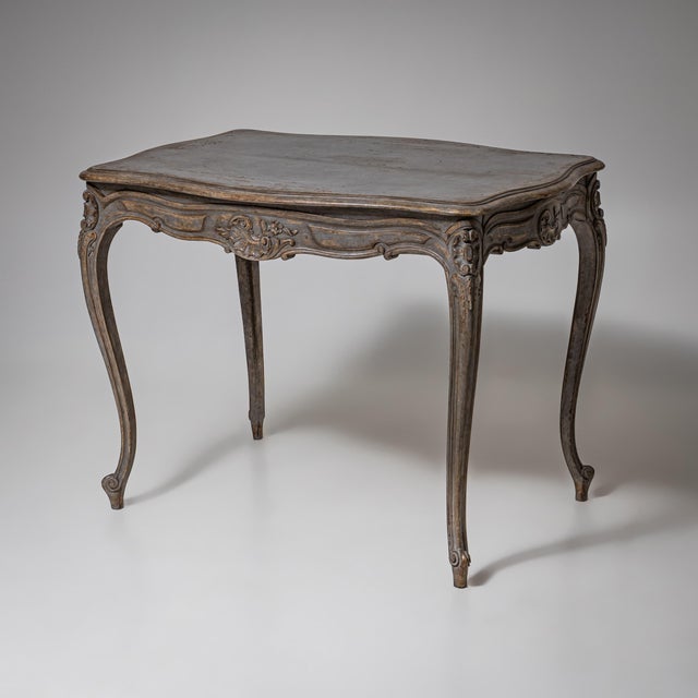 Painted table in Rococo style with cabriole legs and a shaped apron carved with shell and rocaille motifs. Newly painted...