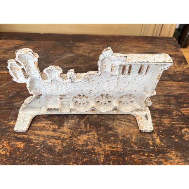 This is a vintage doorstop. It depicts a locomotive train collectible. It has a classic steam engine silhouette. It was...