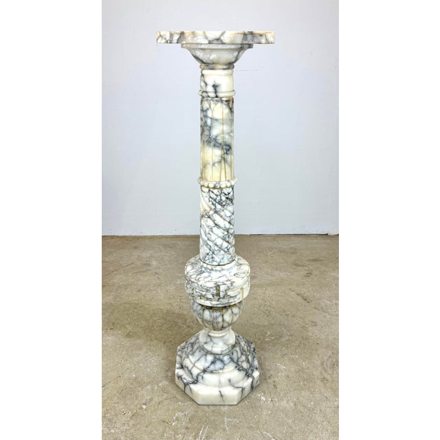 A beautiful old carved white marble pedestal with veins of gray made in Italy circa early 20th century. Features a variety...