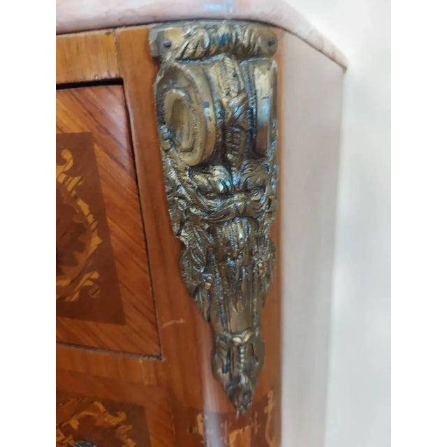 An elegant French-style marble-top commode showcasing exceptional decorative craftsmanship and Old World sophistication....