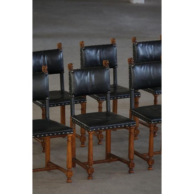 Elegant set of eight dining chairs crafted in oak wood with black leather upholstery. The design reflects the Swedish...
