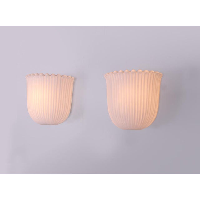 Elegant pair of vintage wall sconces with white opaline glass on a metal frame. Manufactured by glashütte limburg in the...