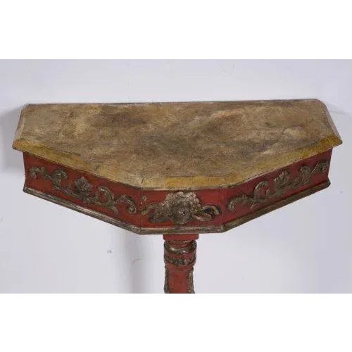 A pair of small Italian consoles in carved painted and gilded wood. The tops painted to simulate marble. The frieze and...