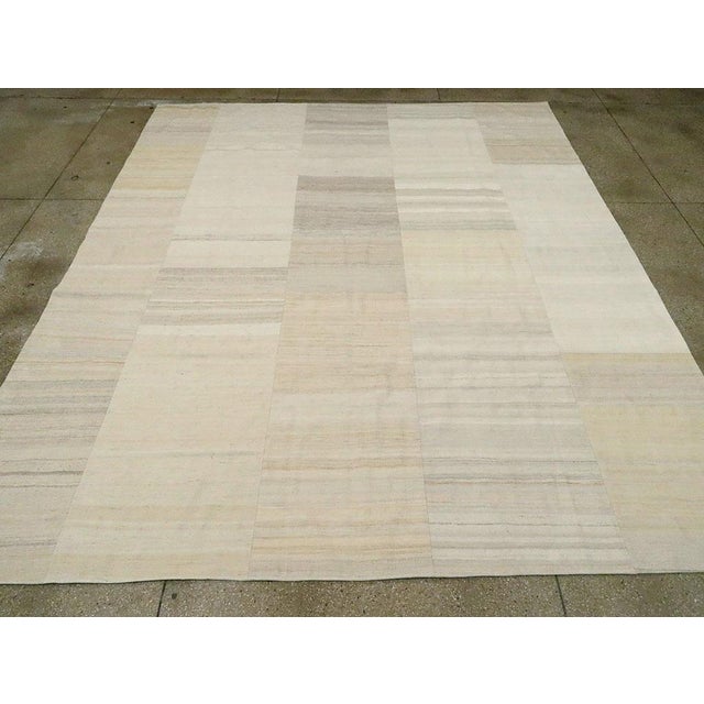 This Mid-20th century Turkish Flatweave Kilim rug, offers a refined expression of Anatolian textile artistry. Composed of...