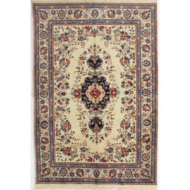 Antique hand-knotted Persian Mashad wool rug with an ivory field centered by a floral medallion, surrounded by delicate...
