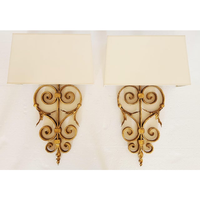 Pair of gilt iron wall sconces from Visual Comfort that bring reliability and solidity to any interior, thanks to its...