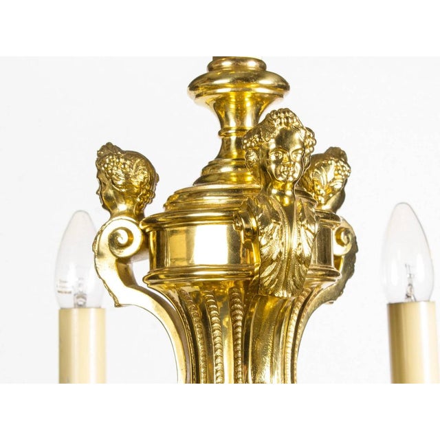 This is a highly decorative French Louis XIV style twelve branch ormolu chandelier, circa 1900 in date. Emanating from a...