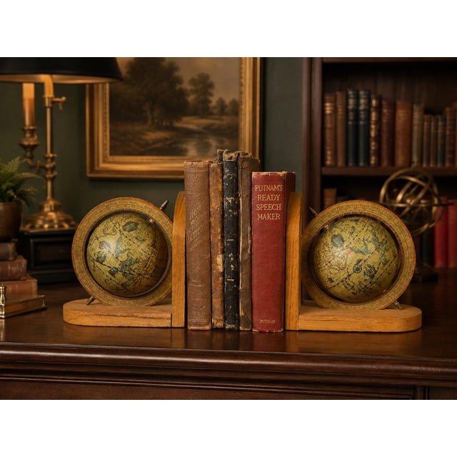 Charming vintage pair of wooden globe bookends featuring rotating Old World-style globes with beautifully aged...