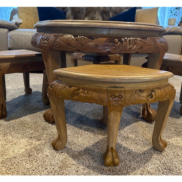 This is a finely crafted solid wood low table with four matching stools, featuring hand-carved narrative and decorative...