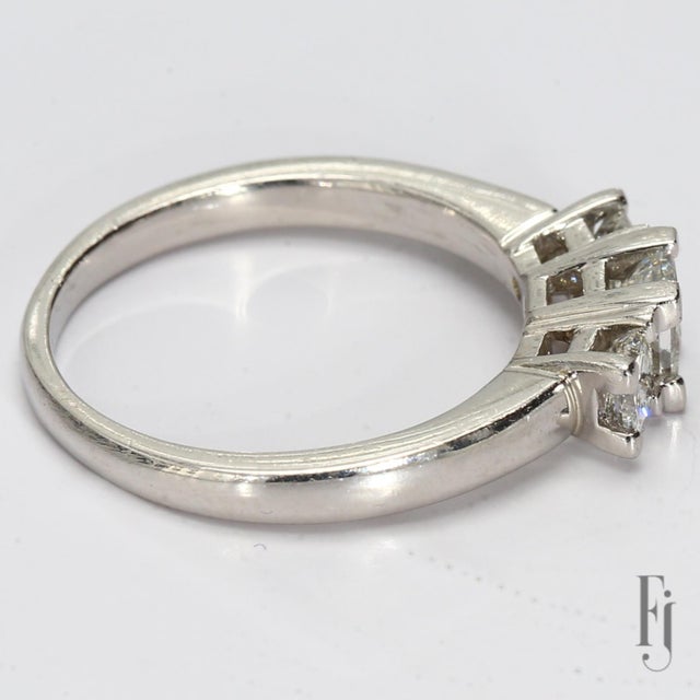 Here is a Platinum Three-Stone Ring with One ~0.47ct. H/VS2 Princess Cut White Diamond Center & Two ~0.27ct. H/VS2 White...