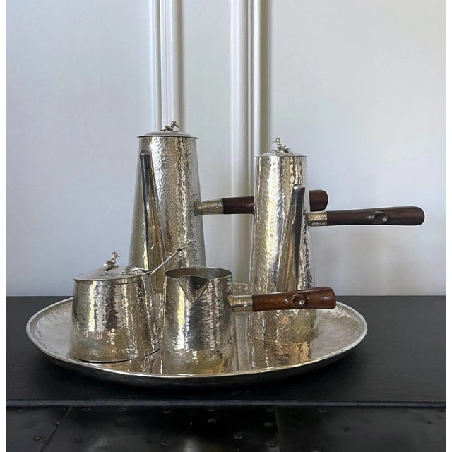 A sterling silver coffee service set consists of six pieces: a coffee pot, a chocolate pot, a covered sugar bowl with a...