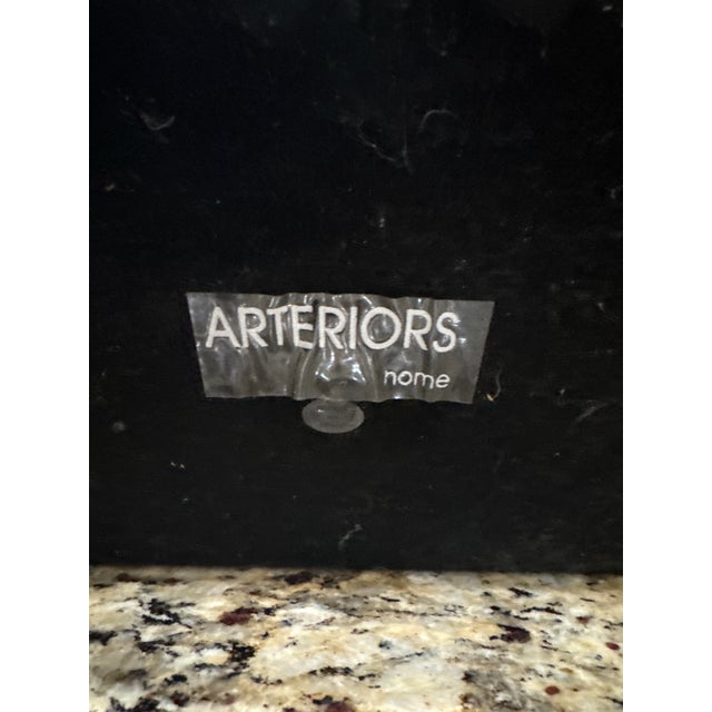 Striking pair of sculptural table lamps by Arteriors Home, featuring polished metal bases with an organic, fluid form and...